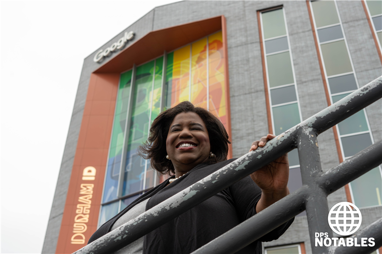  Lilyn Hester standing in front of Google Durham headquarters building.